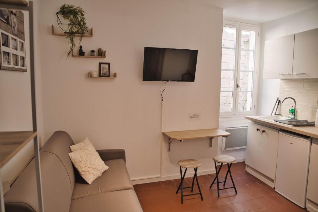 sala de estar con sofá y TV en la pared en Beaucaire cocoon 3/quais/cité médiévale/nature, en Beaucaire