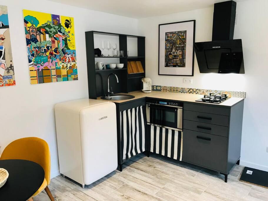 a small kitchen with a sink and a refrigerator at L’Appar(T) du Grand Bois - Jacuzzi - in Soucelles