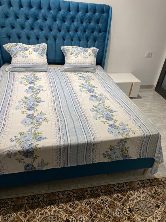 un lit avec une tête de lit bleue et un couvre-lit bleu dans l'établissement Entre Mer et Lac de la Goulette, à La Goulette