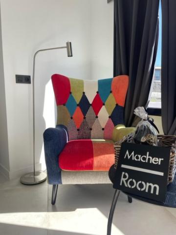 Zimmer mit einem Stuhl und einem Marktzimmerschild in der Unterkunft Macher Room in Mácher
