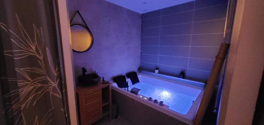 ein Badezimmer mit einer Badewanne mit blauen Fliesen in der Unterkunft Il Était Une Fois - GAP Chambre romantique & SPA in Gap