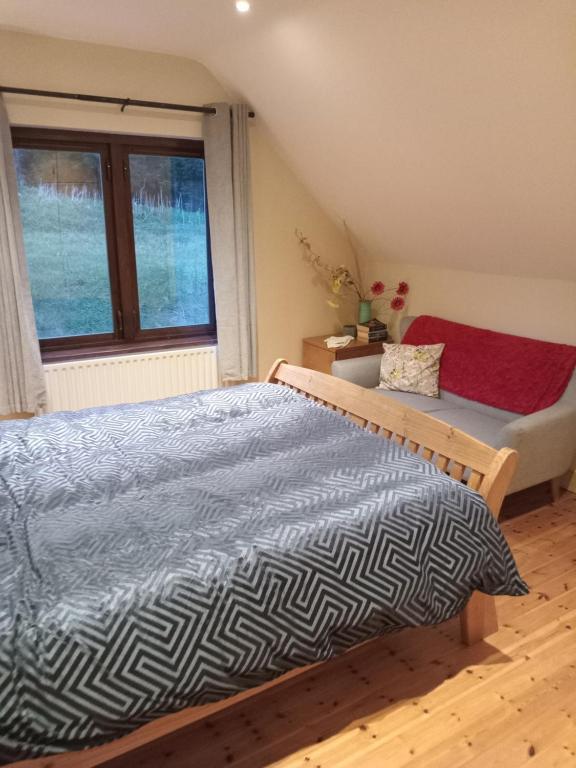 1 dormitorio con cama y ventana en Coastal village retreat en Castletownshend
