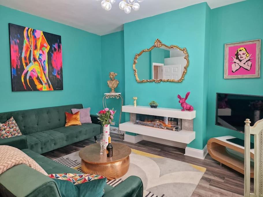 a living room with a green couch and a mirror at Eclectic 1BD in the Heart of Cheltenham! in Cheltenham