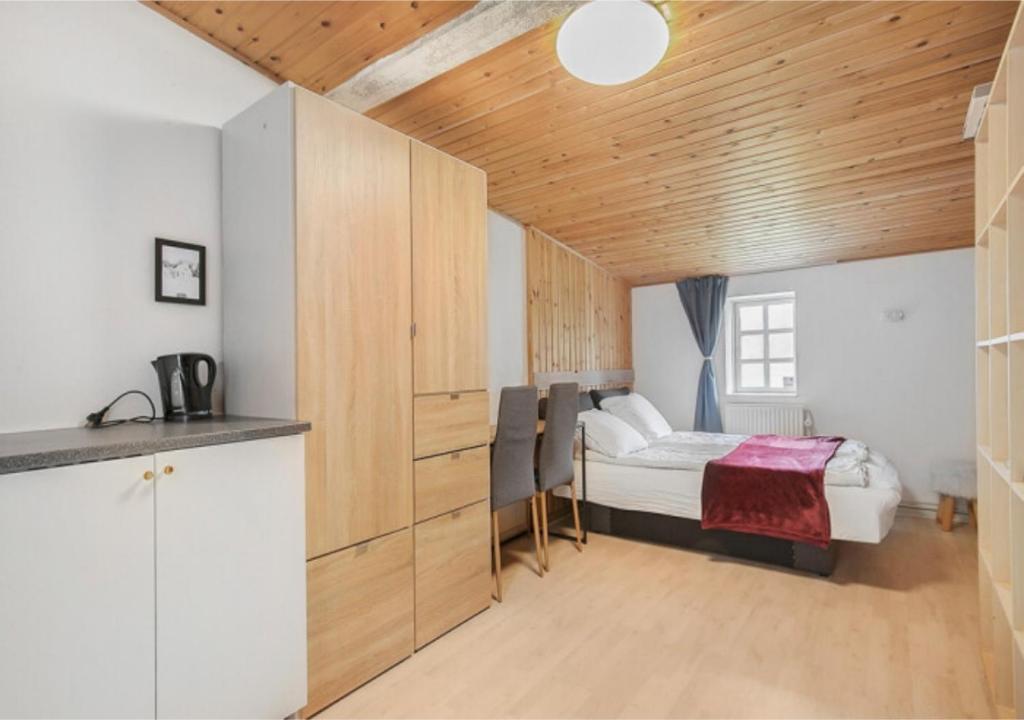 een kleine slaapkamer met een bed en een keuken bij Cosy private room in Slagelse