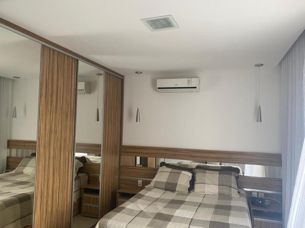 a bedroom with two beds and a mirror at Cidade Nova, Gov. Valadares in Governador Valadares