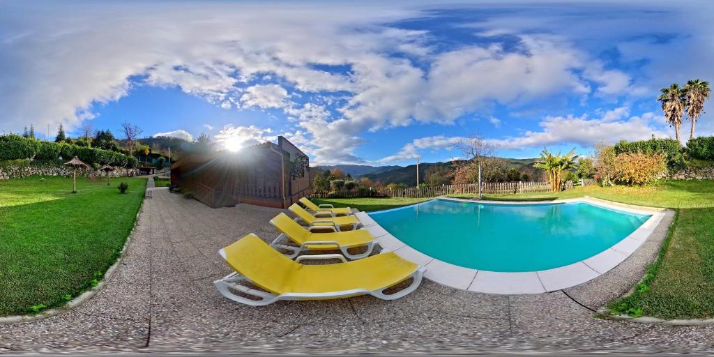 a group of yellow lounge chairs and a swimming pool at Casa dos Cortinhais in Vieira do Minho