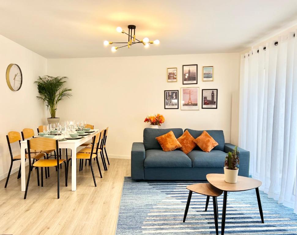 - un salon avec un canapé bleu et une table dans l'établissement House climatisée & parking à 15 minutes de Paris, à Bagneux