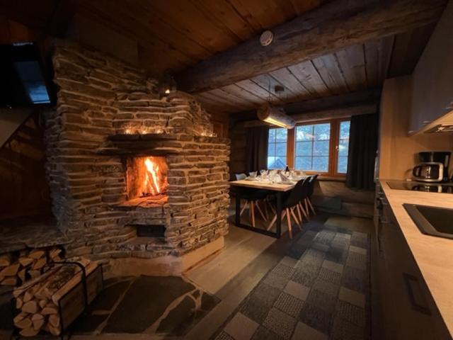 a large stone fireplace in a kitchen with a table at Ruka Saaruakuja 3 as 1-4 in Ruka