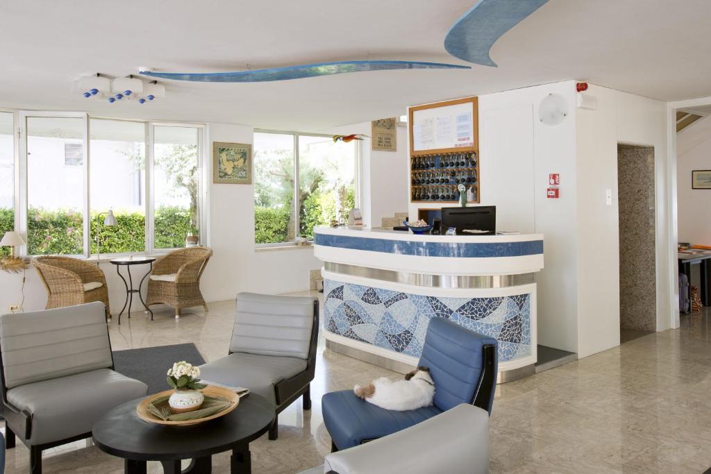 une salle d'attente avec des chaises et un comptoir dans l'établissement Hotel B&B Avana, à Lido di Savio