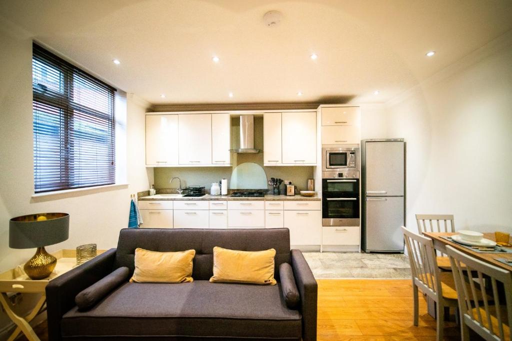 a living room with a couch and a kitchen at Stay with Serena Homes , One bedroom apartment in Purley