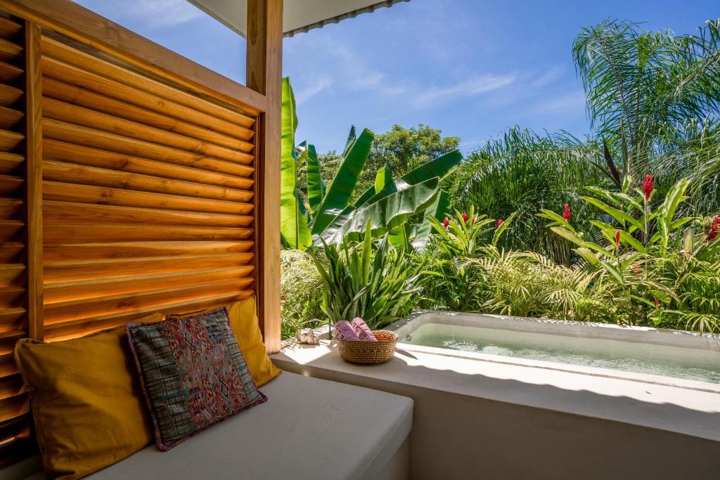 a window seat with a view of a garden at Botanika Suites in Santa Teresa Beach