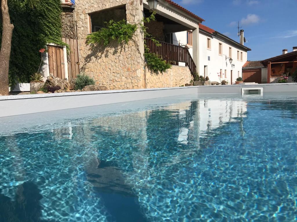 una piscina de agua azul frente a una casa en ACOLINA, en Aguda