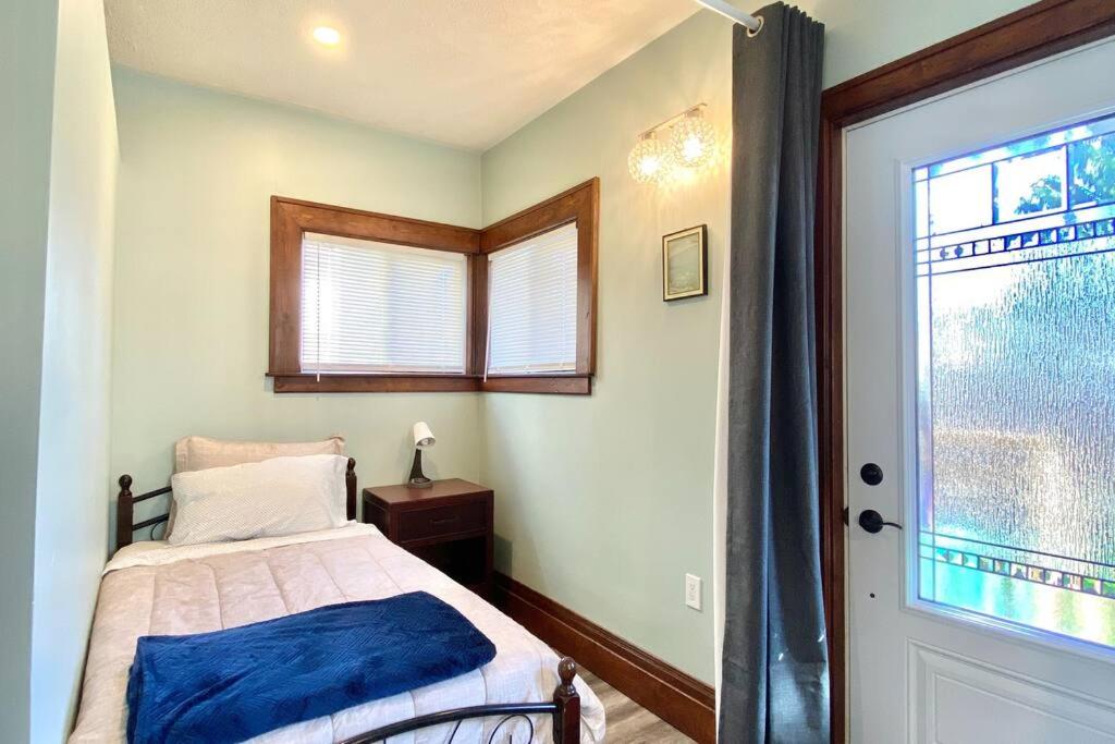 a bedroom with a bed and a window and a door at Cozy Suite-Walk to the Falls! in Niagara Falls