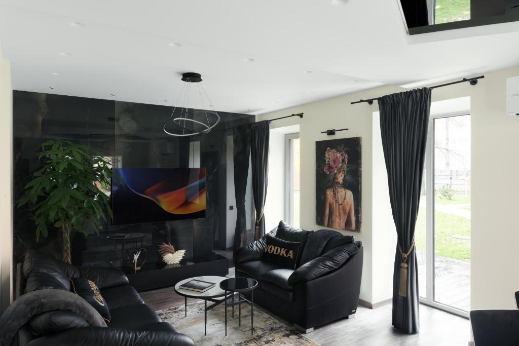 una sala de estar con 2 sofás de cuero negro en Koralas, en Klaipėda