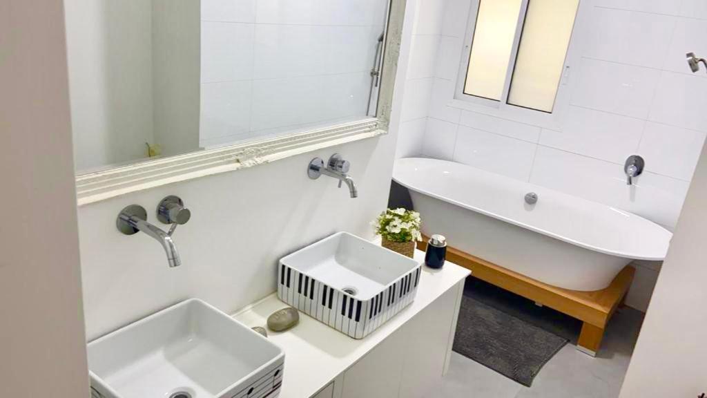 ein Badezimmer mit einer Badewanne, einem Waschbecken und einer Badewanne in der Unterkunft בית פרטי מדהים עם ממ"ד במושב פסטורלי ליד תל אביב in Mazor