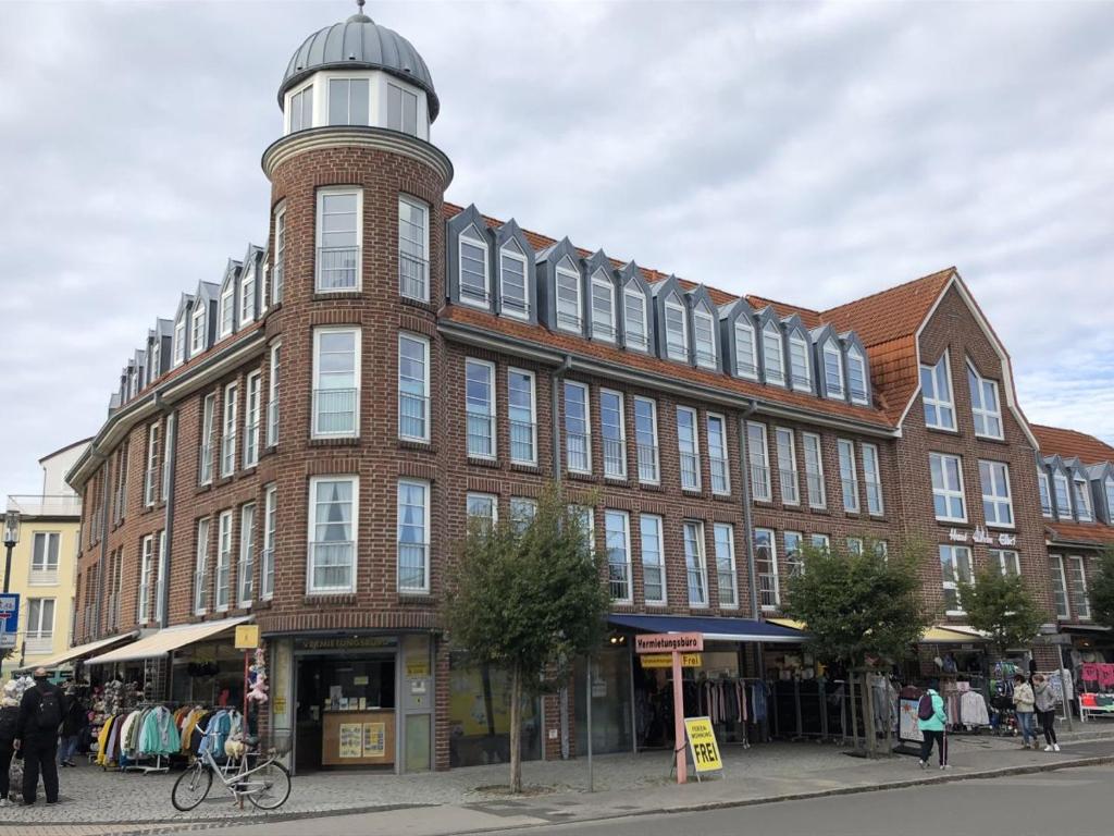 un grand bâtiment en briques avec une tour en haut dans l'établissement Traumhafte Ferienwohnung "Seeküste" in Cuxhaven - Duhnen in 1A LAGE im Haus Elbe 1 !!! 50m zum Strand !!!, à Cuxhaven