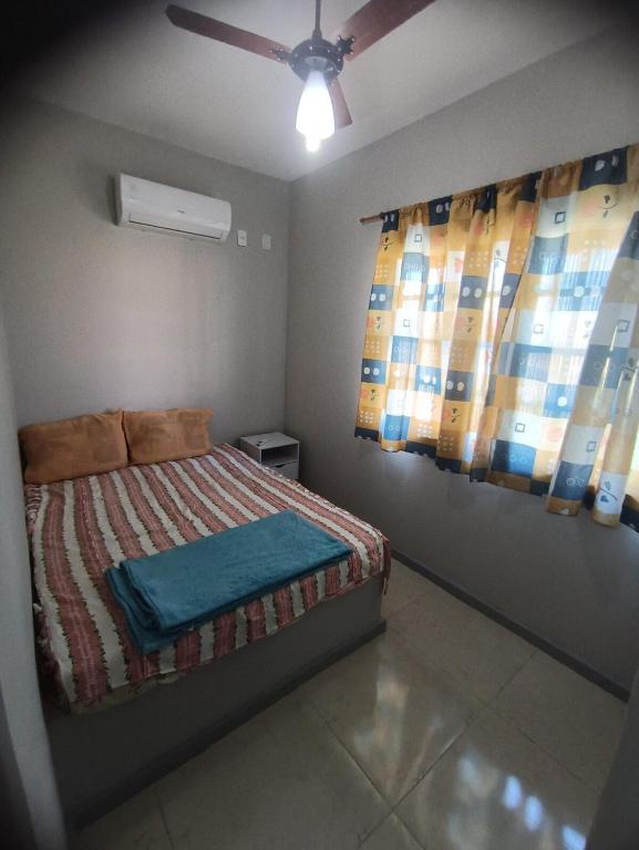 a bedroom with a bed and a ceiling fan at Jardim das orquideas 2 in Rio das Ostras