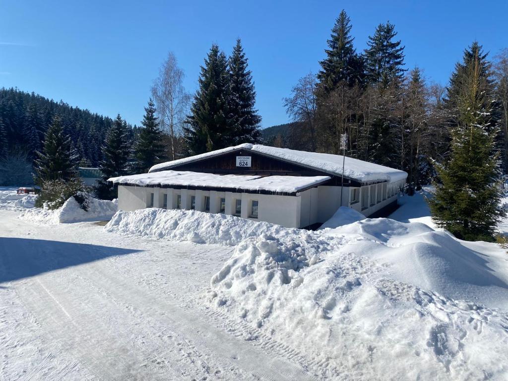 a snow covered building with a pile of snow at Harrachov 624 in Harrachov