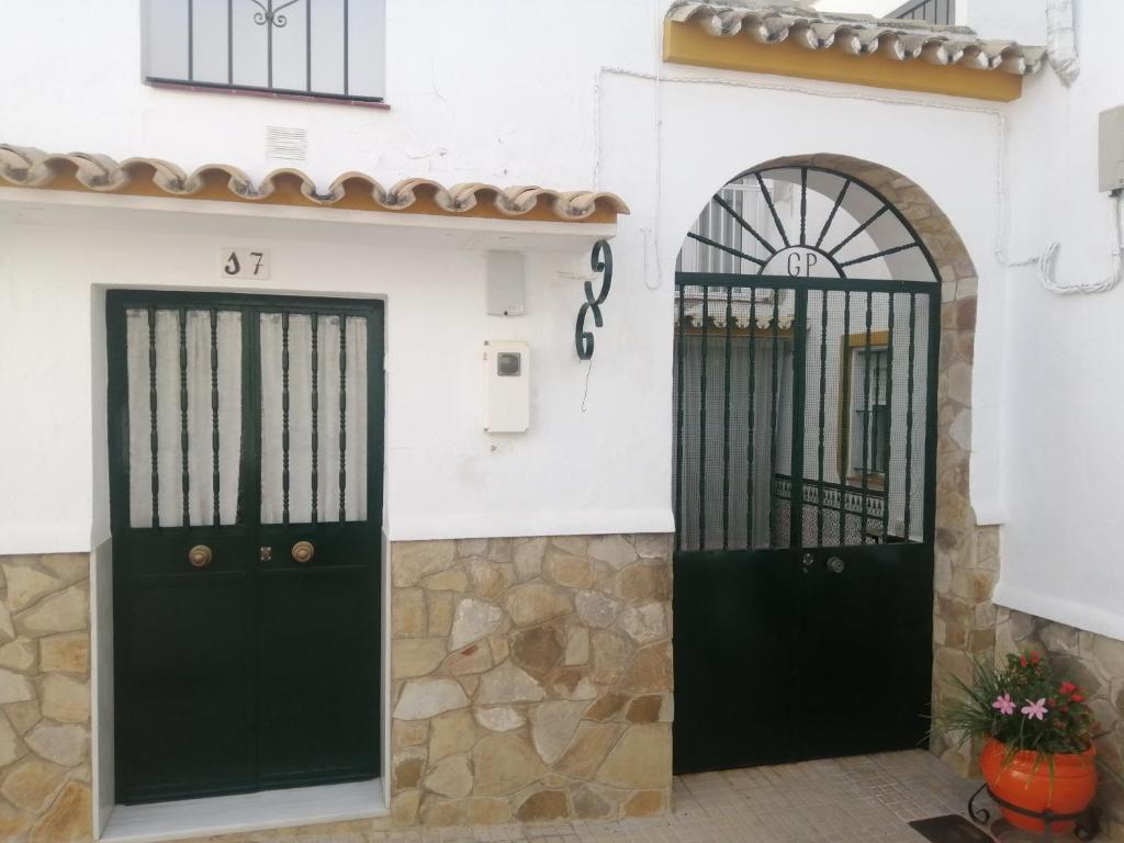 dos puertas negras en un edificio blanco con patio en EL RINCON DEL MARQUES, en Alcalá de los Gazules