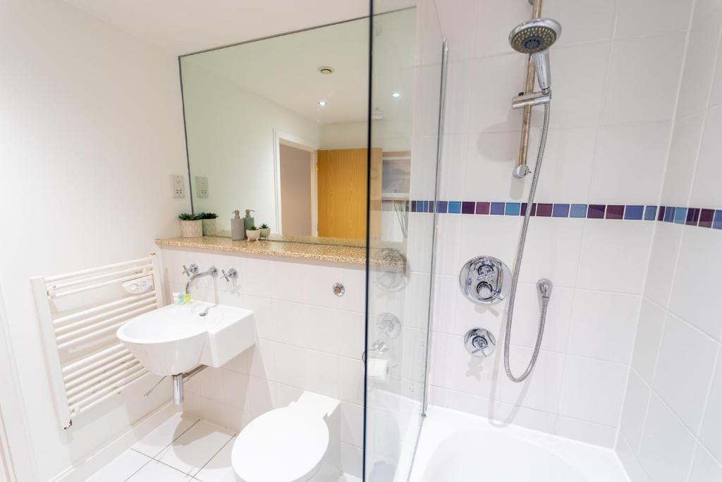 a bathroom with a shower and a toilet and a sink at Superb 1 Bedroom Serviced Apartment In City Centre in Birmingham