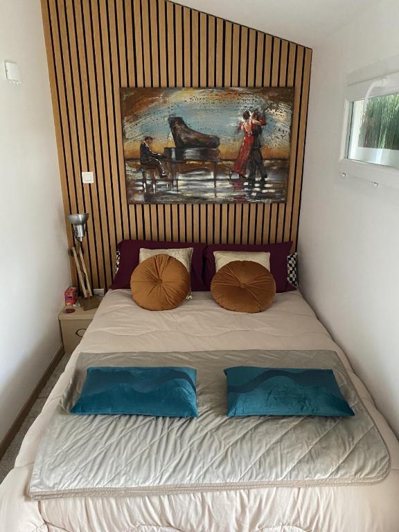 a bedroom with a bed with a painting on the wall at Paris-Zénith-bienvenue-terrasse-Netflix in Pantin