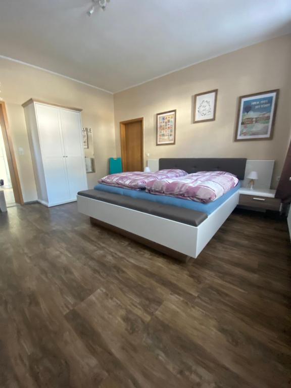 Schlafzimmer mit einem Bett und Holzboden in der Unterkunft Das Rübezahl in Bad Elster
