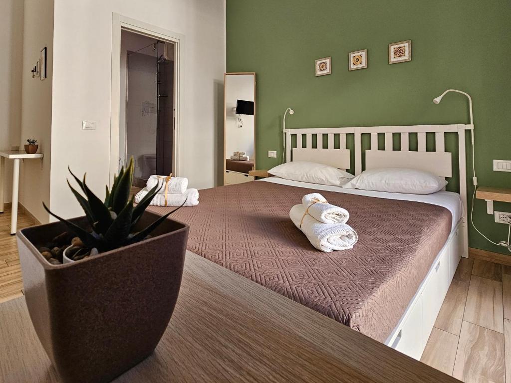 a bedroom with two beds with towels and a plant at Teatro Del Sole Maqueda in Palermo