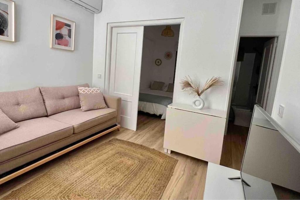 sala de estar con sofá y espejo en Céntrico+nuevo APT,100% equipado, en Madrid