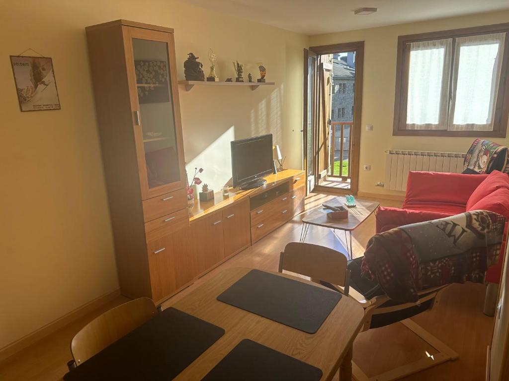 sala de estar con sofá y TV en Apartamento Espata en Villanúa, en Villanúa