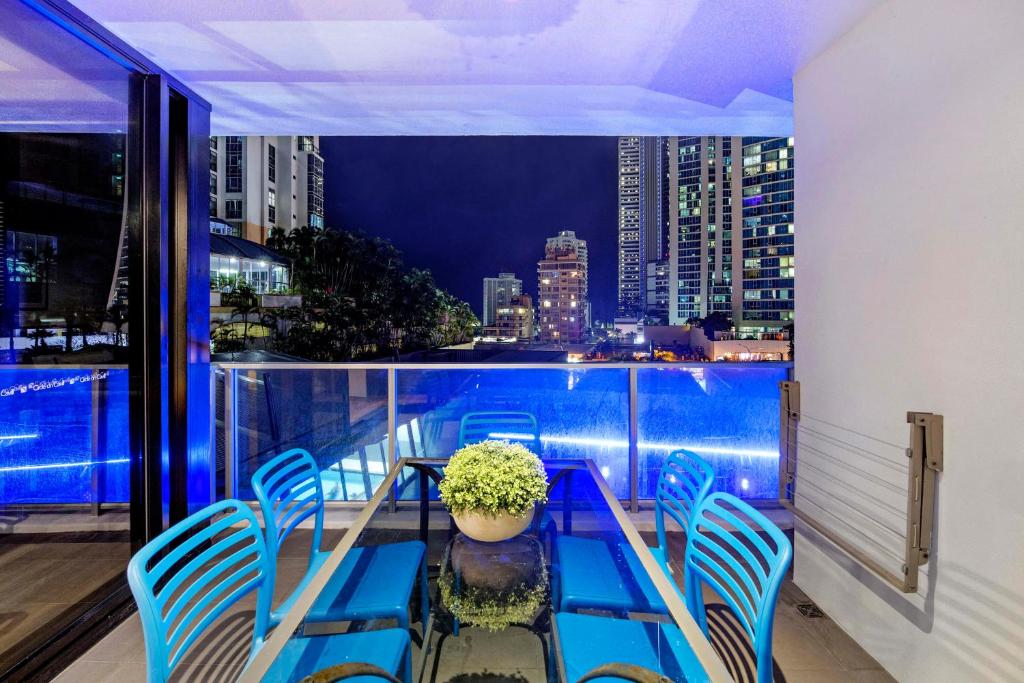 balcón con mesa, sillas y vistas a la ciudad en Circle on Cavill - Level 5 - Sleeps 8 - Wow Stay, en Gold Coast