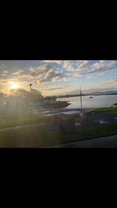 a view of the sun setting over a body of water at Cosy Seaside Home in Groomsport