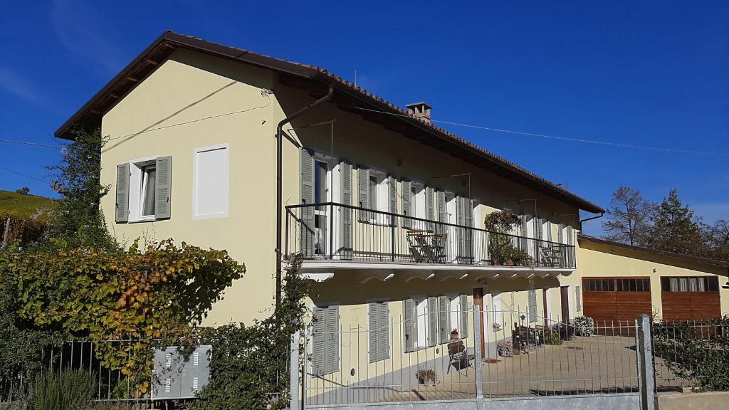 a yellow and white building with a balcony at Ciabot delle Aie - Barolo in Barolo