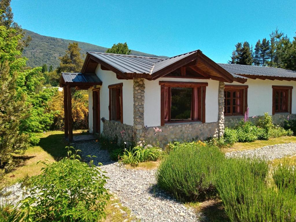 una pequeña casa en medio de un jardín en Cabañas Aldea de Montaña en Lago Puelo