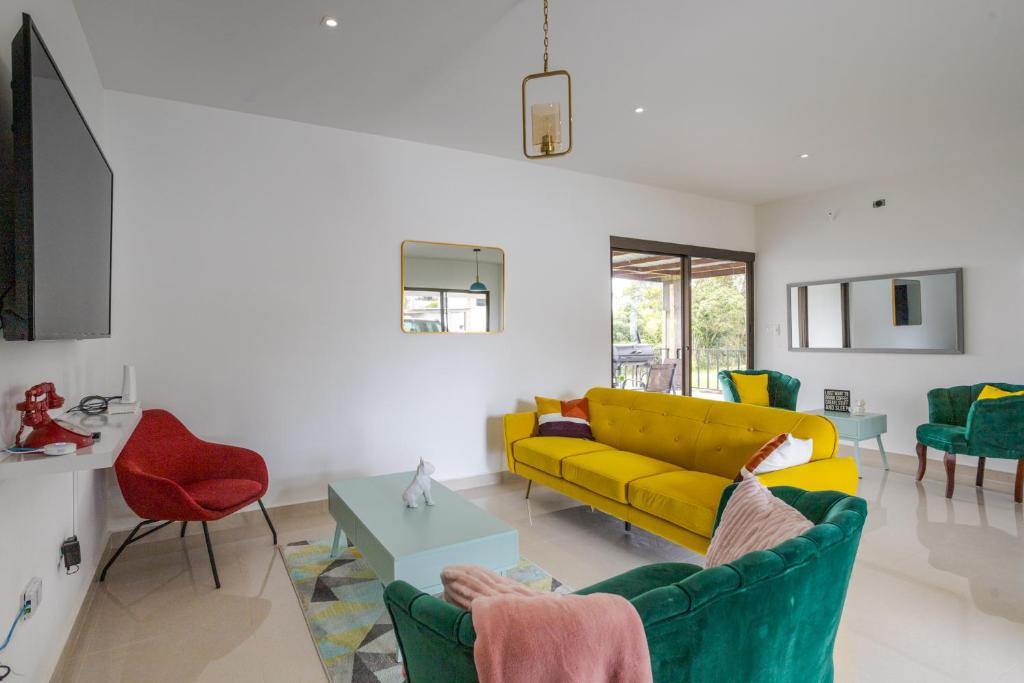 uma sala de estar com um sofá amarelo e cadeiras em Beautiful Family Home in Boquete em Alto Boquete