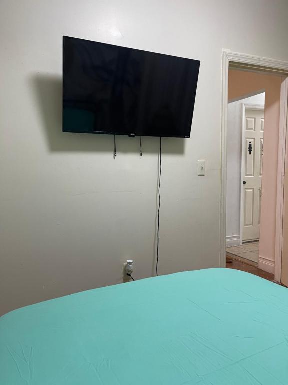 TV de pantalla plana colgada en la pared en SUITE Dreams CARROLL 11 en Paterson