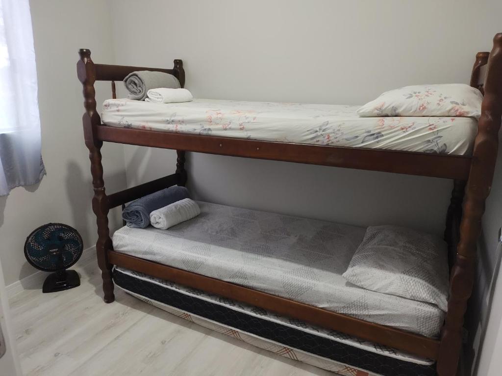 ein paar Etagenbetten in einem Zimmer in der Unterkunft AP Completo NOVO, com Ar condicionado, internet rápida e Garagem privativa in Paranaguá