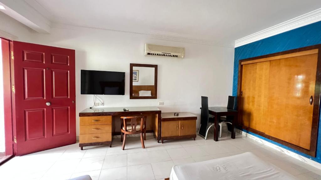 a room with a desk and a tv and a red door at SharmStar in Sharm El Sheikh