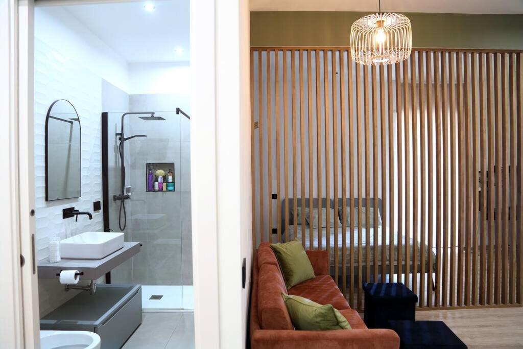Un baño con un sofá junto a un lavabo. en La Casa di Gadu, en Casalnuovo di Napoli