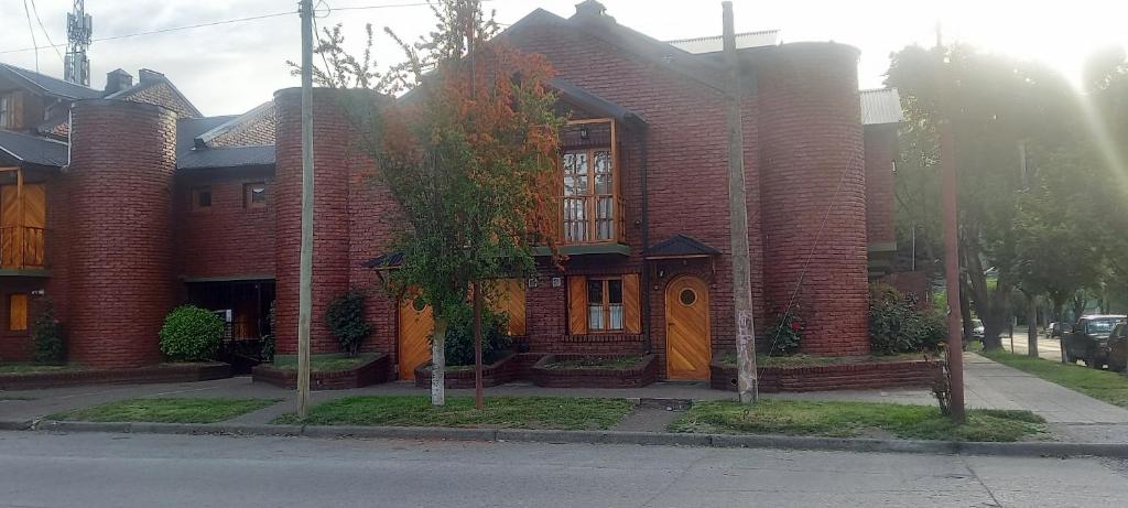 una casa de ladrillo rojo al lado de una calle en Departamento San Martin de los Andes Zona Centro en San Martín de los Andes