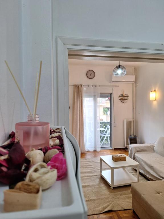 een woonkamer met een bank en een tafel bij Comfortable near metro by hospitality gr in Athene