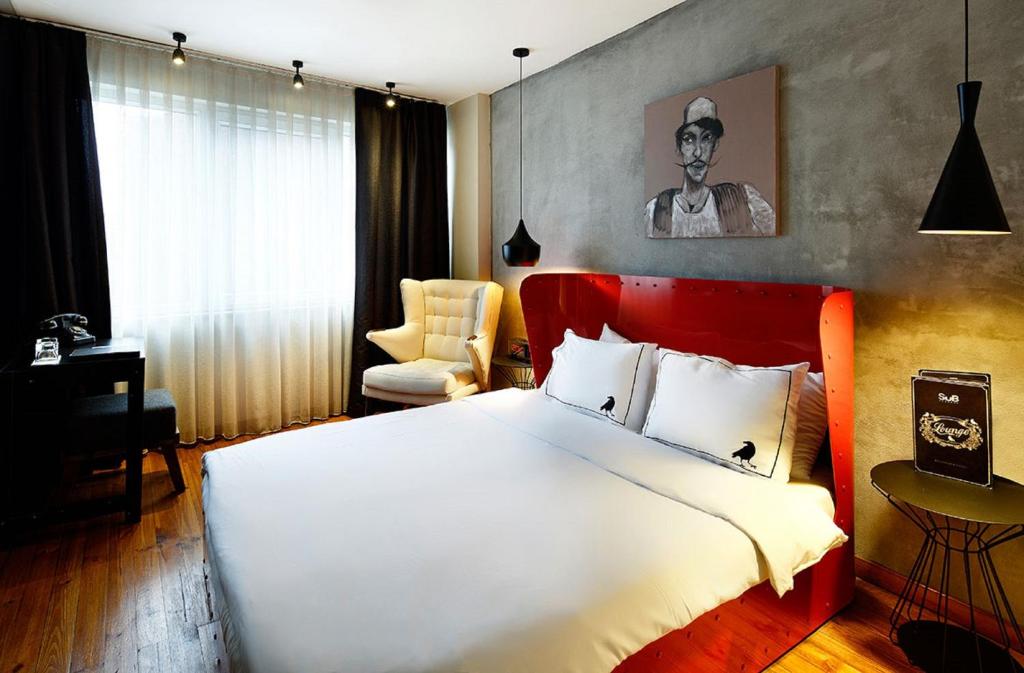 a bedroom with a large white bed and a chair at SuB Karakoy - Special Category in Istanbul
