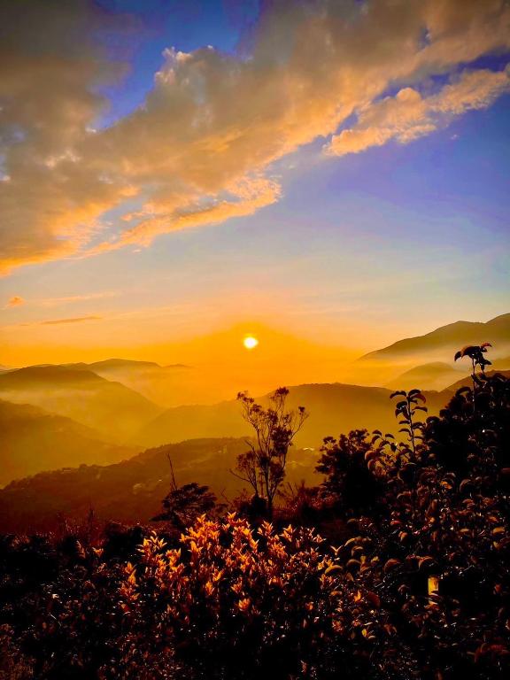 a sunset on a mountain with the sun in the sky at Junyi Landscape Villa in Ren&#39;ai