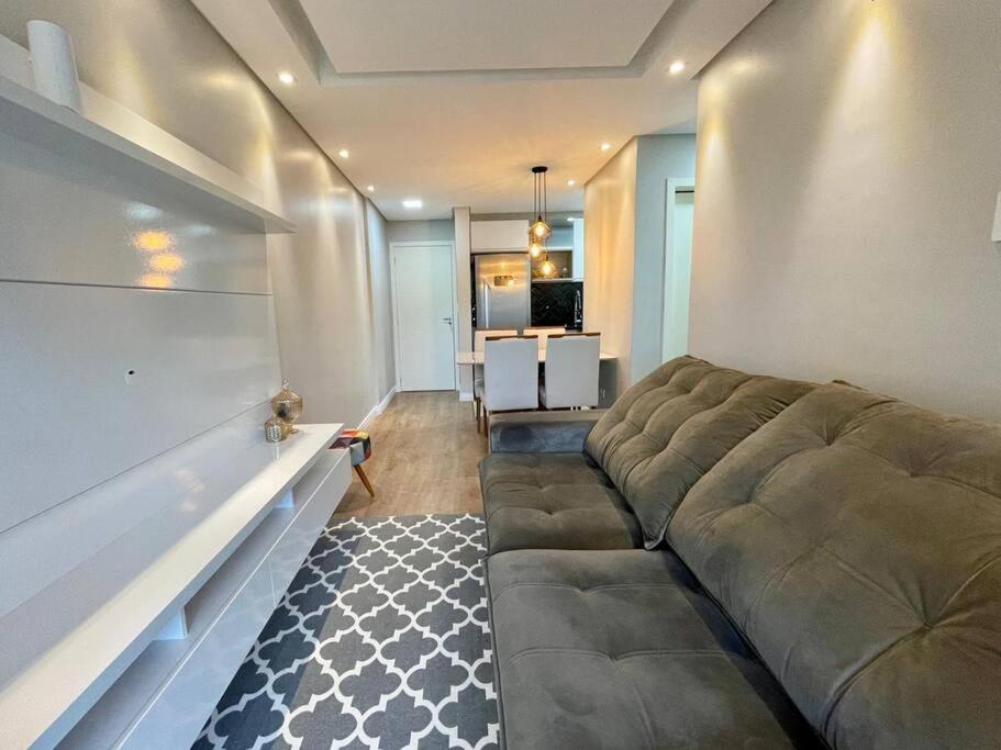 a living room with a large couch and a table at Apartamento no Canto do Forte - Praia Grande in Praia Grande