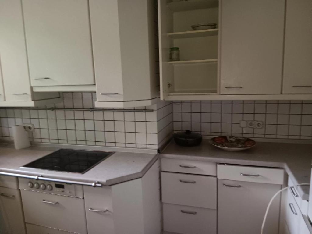 una cucina con armadi bianchi e piano cottura di AH G3 EG a Schwalmtal