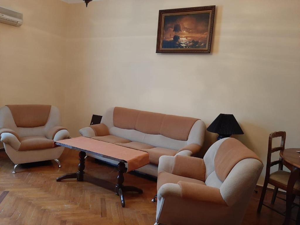 een woonkamer met banken en een tafel en stoelen bij F1 Track View Balcony ZARIFA ALIEVA Street in Baku