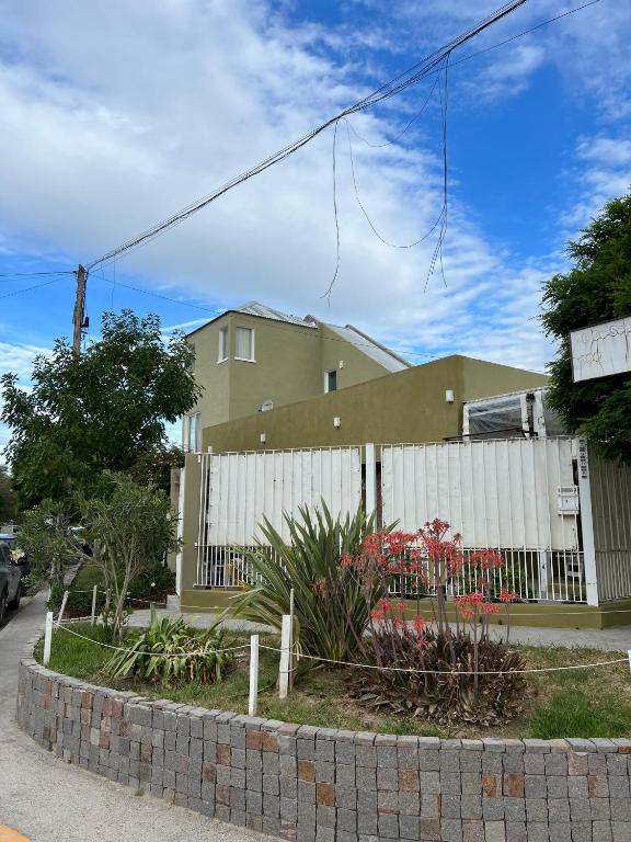 dom z białym płotem i kwiatami w obiekcie De norte a sur w mieście Puerto Madryn