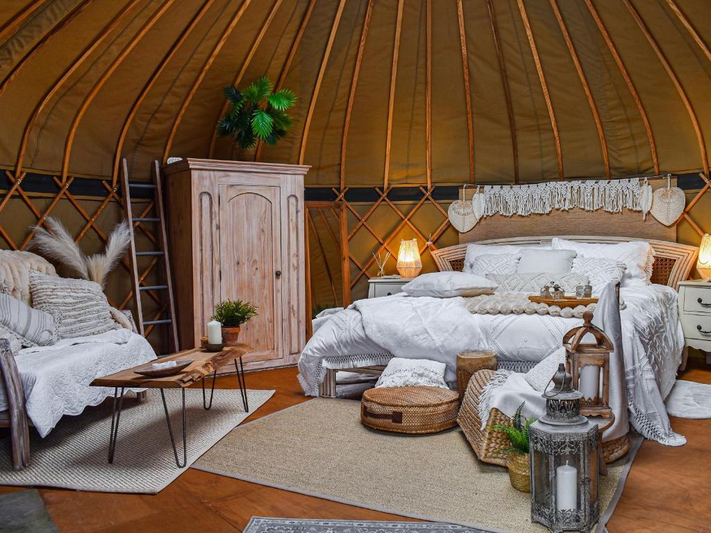 a bedroom in a yurt with a bed and a table at Little West View in Chard