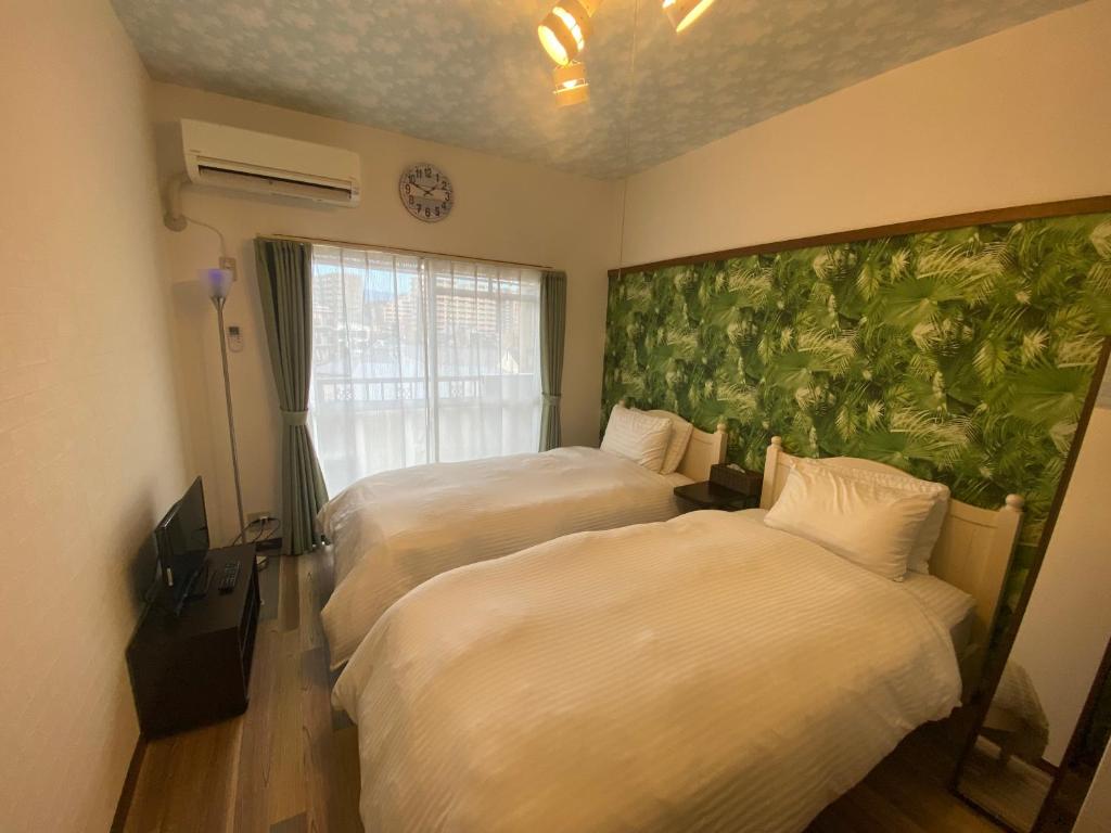 a hotel room with two beds and a wall mural at ラ・ポート空港前201 in Fukuoka