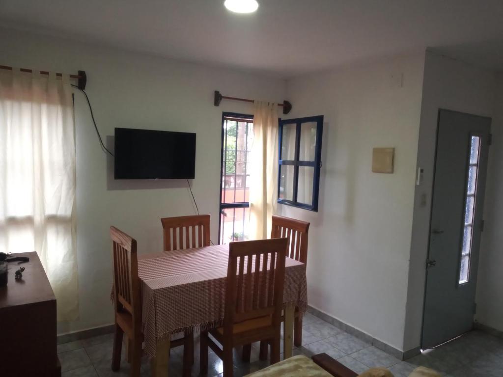 ein Esszimmer mit einem Tisch, Stühlen und einem TV in der Unterkunft La casa de Tilili in Puerto Iguazú