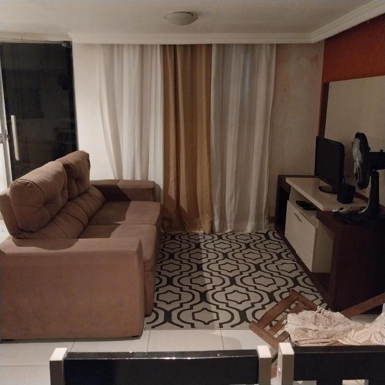 uma sala de estar com um sofá e uma televisão em à 5 minutos do Parque do Povo em Campina Grande
